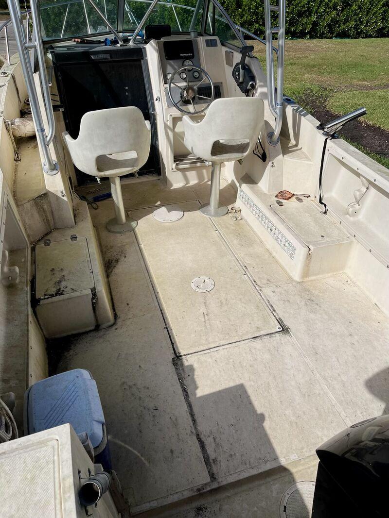 Boat cockpit and helm before detailing, showing stained vinyl and dirty surfaces